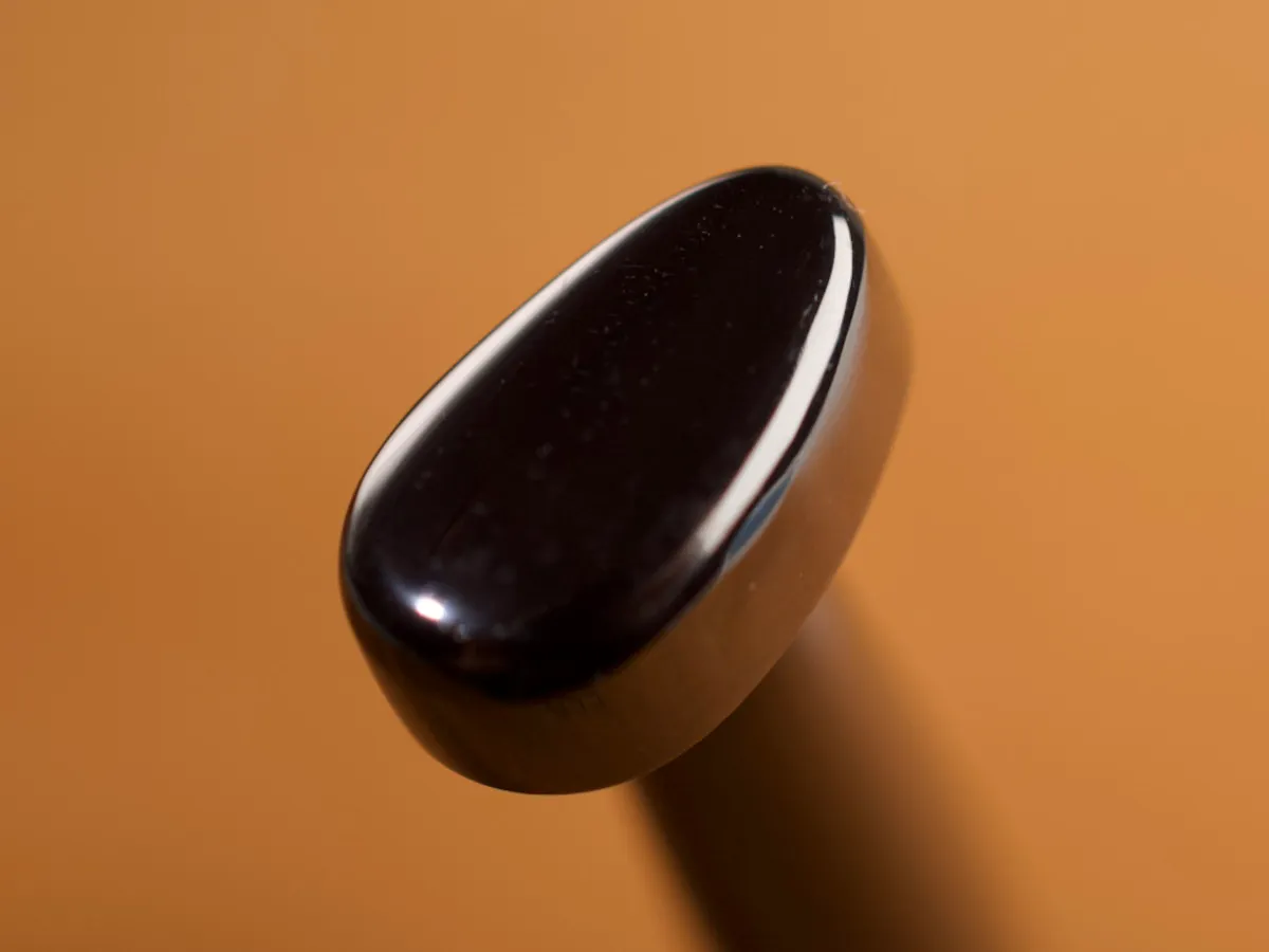 A detailed macro closeup of a pear shader leatherworking tool with a smooth leather background.